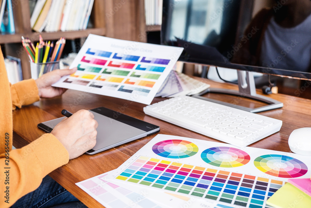 Aufkleber Image of female creative graphic designer working on color selection and drawing on graphics tablet at workplace with work tools and accessories