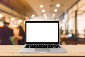 Blank screen laptop computer on wood table top with blur cafe restaurant with abstract bokeh light defocused background