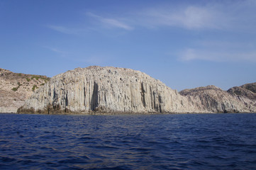 View of the white and yellow mountains of the cliffs growing from the sea on the shore from a boat. Blue Lagoon. © Payllik
