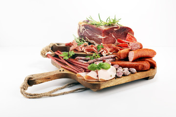 Food tray with delicious salami, pieces of sliced ham, sausages,salad and vegetable. Meat platter with selection