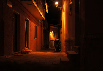 Night cityscape evening streets with yellow glowing lanterns. Italian old medieval european architecture.