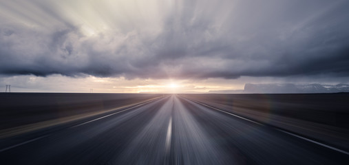 Road leading towards sunset with motion blur effect