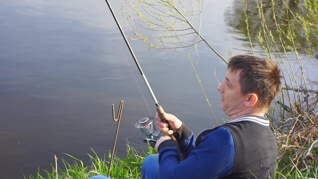 Fisherman turns the coil to pull the fish.1920X1080 Full Hd.