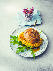 Vegetarian cauliflower burger on a plate with red cabbage salad