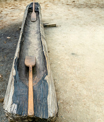 An empty Indian canoe with oars on the ground
