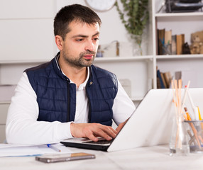 Businessman in shirt working with laptopt and documents