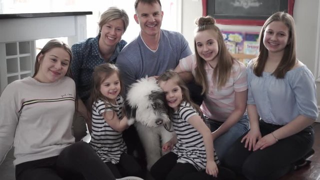 A Portrait of nice cute cheerful big family parent with the twin girls and children with bobtail dog