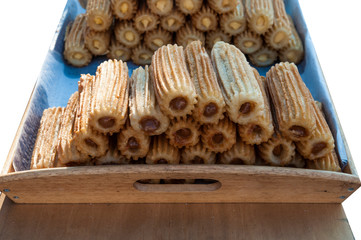 sweet waffle cakes with chocolate filling on wooden tray on white background