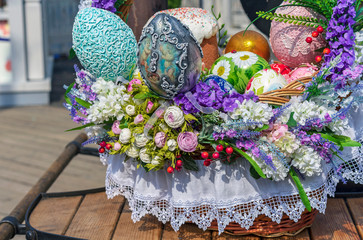 Colorful Easter eggs and Easter cakes in a wicker basket.