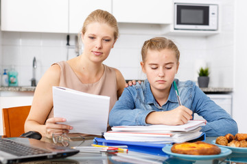 Mother helping daughter with home task