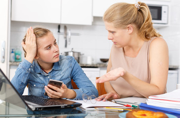 Fototapeta premium Mother scolds her daughter for playing smartphone