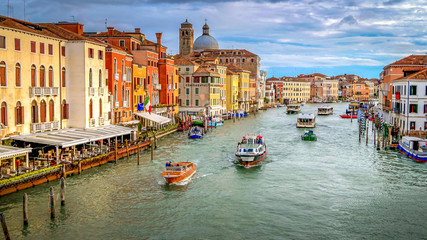 Fototapeta na wymiar Vaporetto, commercial boats and water taxi's traverse the Grand Canal in Venice, Italy