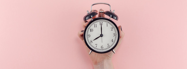 Female hand with alarm clock. Morning concept