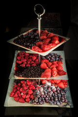 assortment of thawed berries served on three leveled plate