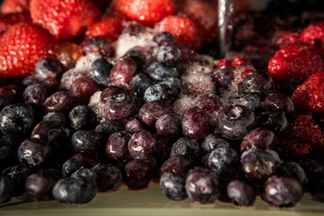 closeup frozen thawed blueberries and strawberries on plate