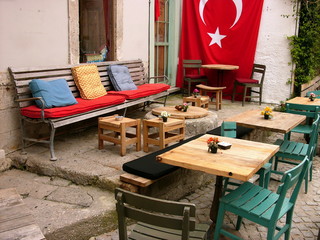 Gemütliche Terrasse mit Tisch, Stuhl, bunten Kissen und türkischer Fahne in den Gassen der...