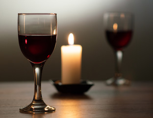 a glass of red wine by candlelight