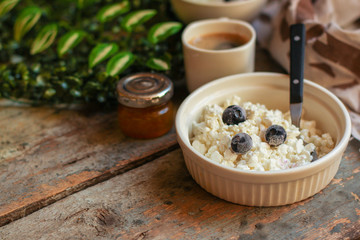 cottage cheese with berries in a plate on the table, healthy food (a portion of vitamin food). food background. top view