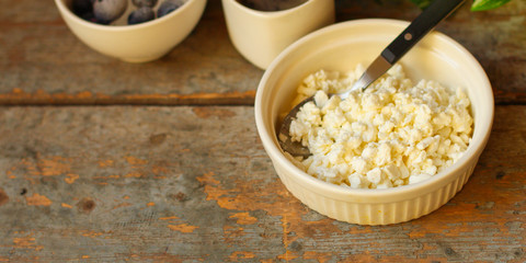 cottage cheese with berries in a plate on the table, healthy food (a portion of vitamin food). food background. top view
