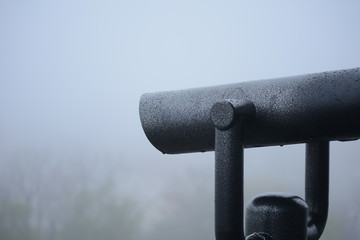 Binoculars to observe the sights on a background of white fog.