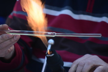 Craftsman glassblower at work. Handmade glass. Fire and glass are melting. Gas burner and flame