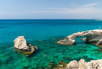 CYPRUS, THE BRIDGE OF LOVERS - MAY 11/2018: Tourists jump from a height into the azure waters of the Mediterranean Sea.