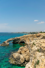 CYPRUS, THE BRIDGE OF LOVERS - MAY 11/2018: Tourists jump from a height into the azure waters of the Mediterranean Sea.