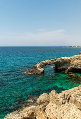 CYPRUS, THE BRIDGE OF LOVERS - MAY 11/2018: Tourists jump from a height into the azure waters of the Mediterranean Sea.