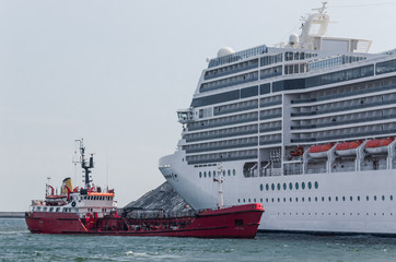 A RED SUPPLY VESSEL - Oil tanker is preparing to bunker fuel for a cruise ship