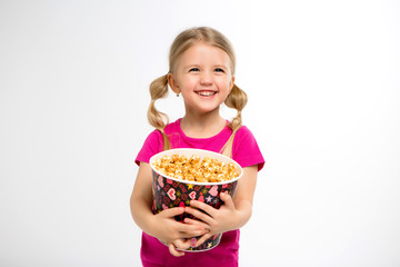 baby girl with popcorn on white isolate background.Little cute baby girl 3-4 years old holding a bucket for popcorn, Kids childhood lifestyle concept. Copy space.