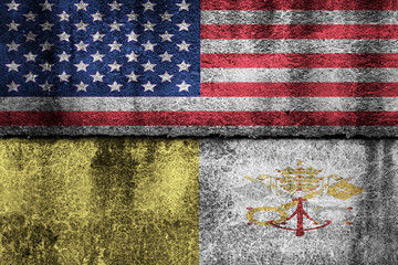 two flags on a cracked wall, USA and Vatican