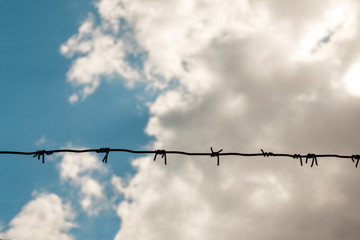 The barbed wire with cloudy sky. concept of forbidden zone, war and military base, copy space for text.