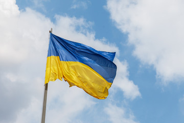 blue and yellow banner is fluttering in the wind in sun rays. concept of Ukrainian patriotism.