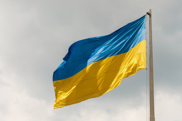 close-up of national symbol of ukrainian people - blue and yellow banner is fluttering in the wind in sun rays. concept of Ukrainian patriotism.