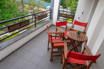 balcony with red wooden chairs