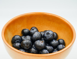 Large ripe blueberries in a ceramic bowl