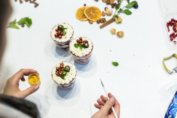 Decoration of the finished dessert. Pastry chef sprinkles confectionery with yellow powder. The concept of homemade pastry, cooking cakes.