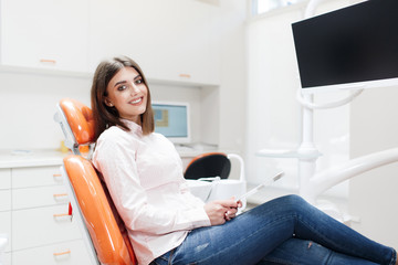 Dental clinic. Reception,examination of the patient. Teeth care. Young girl smiling, looking in the...