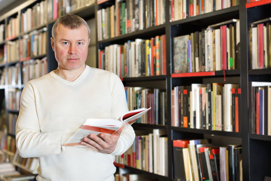 Man browsing inside of books while visiting library