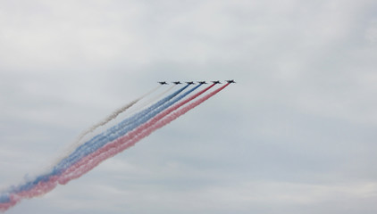 Planes making tricolor smoke trail at airshow in Saint Petersburg, Russia
