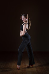 beautiful girl wearing black sportswear is training in the dance studio