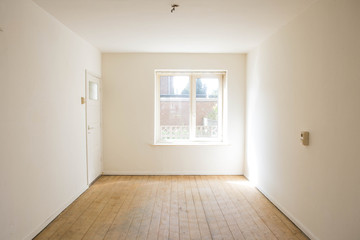 empty white room with wooden parquet floor before renovation