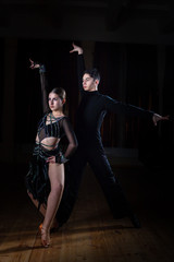 Beautiful young dancers in ballroom isolated on black background