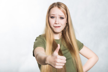 Young beautiful woman shows thumbs up sign. Body language concept.