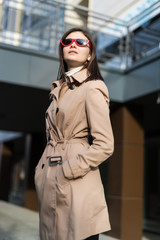 Obraz premium Young stylish woman walking on the street wearing stylish bright coat and skirt.