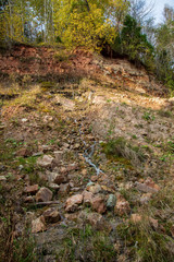 sandstone cliffs with waterfall near river