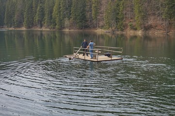 Obraz premium Rower on a raft in the middle of Lake Synevir. Carpathian mountains. Ukraine.