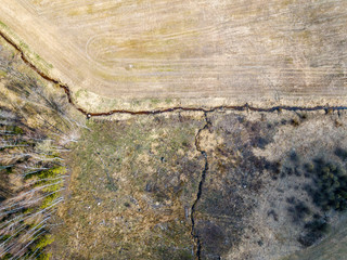 aerial view of small country river bed wavy in spring time in countryside