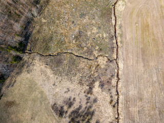 aerial view of small country river bed wavy in spring time in countryside