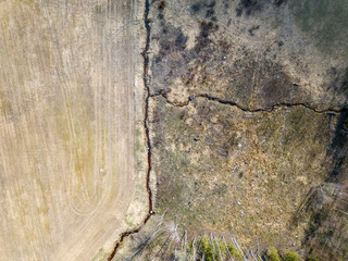 aerial view of small country river bed wavy in spring time in countryside